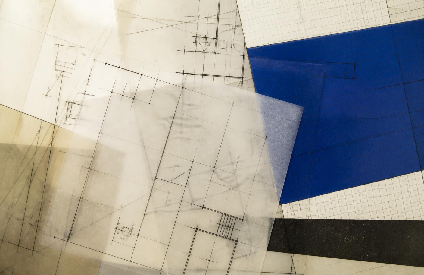 Abstract composition of overlapping translucent engineering drawings, grid paper and a single deep blue panel